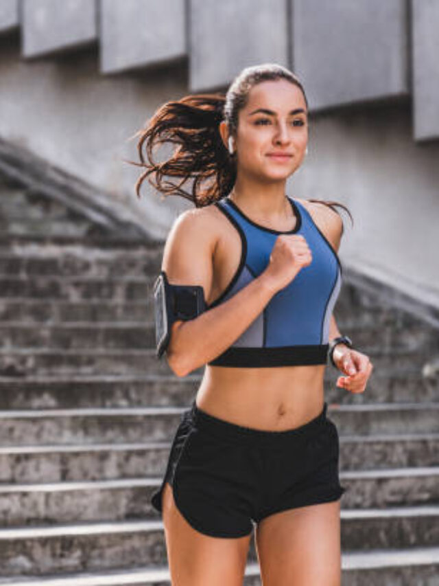 Young caucasian woman runner jogging on the stairs in sporty outfit outdoors